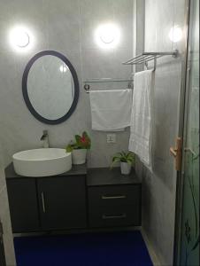 a bathroom with a sink and a mirror at Save Sweet Home in Fuvahmulah