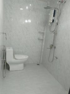 a white bathroom with a shower and a toilet at Save Sweet Home in Fuvahmulah