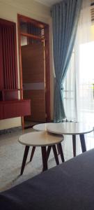 a living room with two tables and a window at Serenity in Kampala