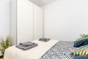 ein weißes Schlafzimmer mit einem Bett mit Handtüchern darauf in der Unterkunft Apartament pod Prezydentem in Bielsko-Biała