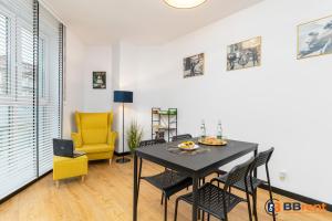 ein Esszimmer mit einem Tisch und einem gelben Stuhl in der Unterkunft Apartament pod Prezydentem in Bielsko-Biała