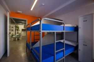 two bunk beds in a room with an orange wall at All Iron Hostel in Bilbao