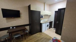 Dieses kleine Zimmer verfügt über eine Küche mit einem Tisch und Stühlen. in der Unterkunft Apartment in the city centr Bursatsky descent in Kharkov + 5 Fotos