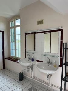 ein Badezimmer mit zwei Waschbecken und zwei Spiegeln in der Unterkunft La gare de Chambretaud in Chambretaud