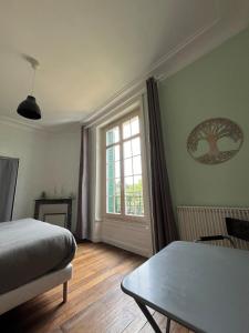 ein Schlafzimmer mit einem Bett und einem Tisch und einem Fenster in der Unterkunft La gare de Chambretaud in Chambretaud