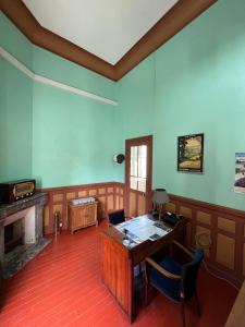 ein leeres Zimmer mit einem Schreibtisch und einem Kamin in der Unterkunft La gare de Chambretaud in Chambretaud