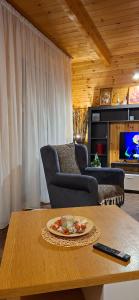 a living room with a table and chairs and a tv at ZlatniBor House in Vodice