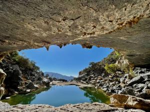 a view of a river through a cave at إطلالة غروب الشمس in Misfāh