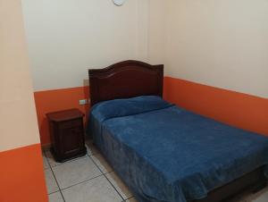 ein kleines Schlafzimmer mit einem Bett und einem Nachttisch in der Unterkunft Hotel Real De Cortes in Xalapa