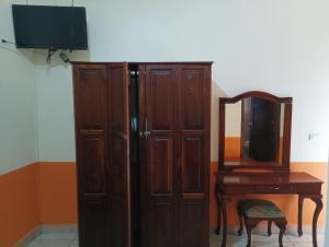 ein Holzschrank neben einem Tisch und einem Spiegel in der Unterkunft Hotel Real De Cortes in Xalapa