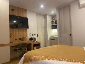 a bedroom with a bed and a desk with a computer at Hotel Ryo 74b Piso 7 Vip in Medellín