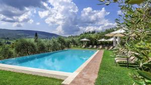 - une piscine dans une cour avec des chaises et des parasols dans l'établissement Historic Farmhouse Overlooking San Gimignano, à San Gimignano