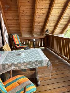 a wooden deck with a table and chairs on it at Ferienwohnung Jägerhaus in Walldürn
