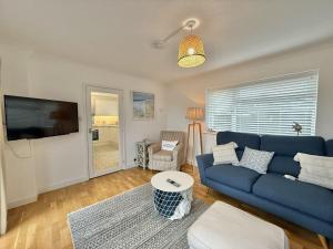 a living room with a blue couch and a tv at SubLyme in Lyme Regis