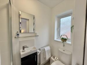 a white bathroom with a sink and a toilet at SubLyme in Lyme Regis +23 photos