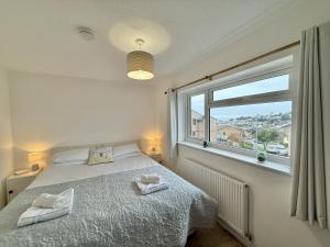 a bedroom with a bed and a large window at SubLyme in Lyme Regis