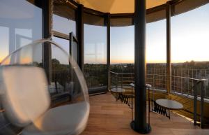 Una habitación con sillas y un balcón con ventanas. en Wasserturm Bad Saarow, en Bad Saarow