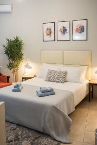 a bedroom with a large bed with towels on it at City Central Apartment with Parking in Larisa