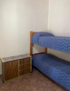 a room with two bunk beds and a wooden cabinet at Dúplex Las Malvinas in El Bolsón