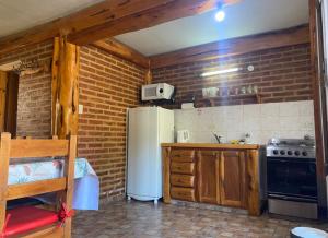 a kitchen with a white refrigerator and a stove at Dúplex Las Malvinas in El Bolsón