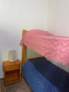 a bedroom with a bunk bed and a night stand at Dúplex Las Malvinas in El Bolsón +4 photos