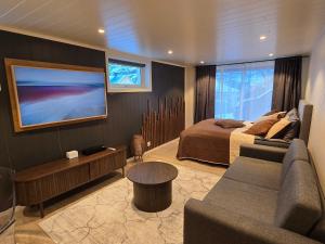 een slaapkamer met een bed, een bank en een tv bij Nord Hus Service AS Nr 2 in Havøysund