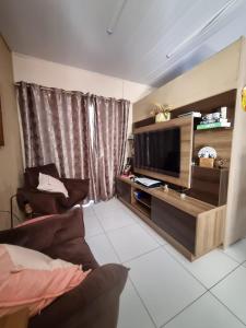 ein Wohnzimmer mit einem TV und einem Sofa in der Unterkunft Coração de São Gabriel in São Gabriel
