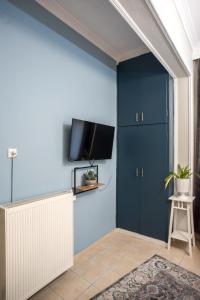 a room with blue walls and a tv on a wall at City Central Apartment with Parking in Larisa