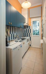 a kitchen with blue cabinets and white appliances at City Central Apartment with Parking in Larisa