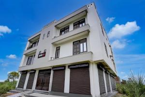 ein weißes Gebäude mit braunen Fensterläden darauf in der Unterkunft SPOT ON Samrat Hotel in Kānpur + 21 Fotos