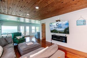 Una sala de estar con un sofá y un televisor de pantalla plana. en Marysol, en Edisto Beach