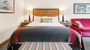 - une chambre avec un grand lit et un canapé rouge dans l'établissement 1334 Studio Spruce Peak Lodge Sleeps 4 Ski in Ski Out, à Stowe Mountain 17 autres photos