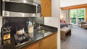 une cuisine avec un évier et une cuisinière four supérieur dans l'établissement 1334 Studio Spruce Peak Lodge Sleeps 4 Ski in Ski Out, à Stowe Mountain