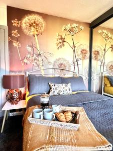 a bedroom with a bed with a tray of food on it at Wharfe View Cottage Ilkley in Ilkley