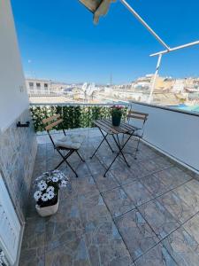 アテネにあるKontaStudioのバルコニーに椅子とテーブルが置かれたパティオ