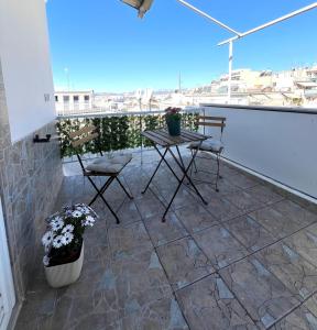 アテネにあるKontaStudioのバルコニーにテーブルと椅子が置かれたパティオ