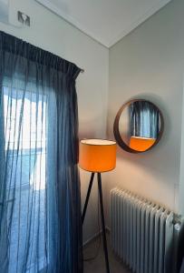 アテネにあるKontaStudioの窓のある部屋の鏡とランプ