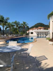 a table and chairs next to a swimming pool at Rio Marina Resort in Mangaratiba