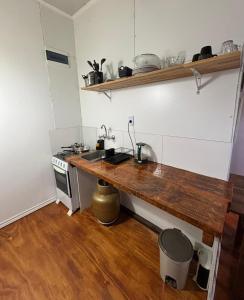 uma cozinha com um balcão de madeira e um fogão em Jacaranda em Neptunia