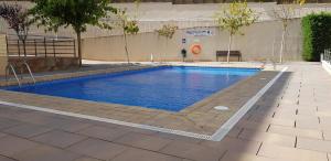 a swimming pool with blue water in a building at Apartamento Clotilde Lloret in Lloret de Mar