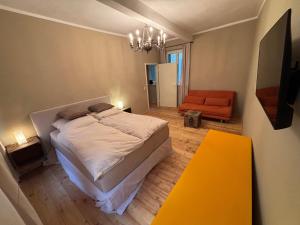 ein Schlafzimmer mit einem Bett und einem orangenen Stuhl in der Unterkunft Cityappartment am Regensburger Dom in Regensburg