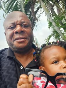 Ein Mann hält ein kleines Mädchen mit Brille im Arm in der Unterkunft Timothee in Cornellà de Llobregat