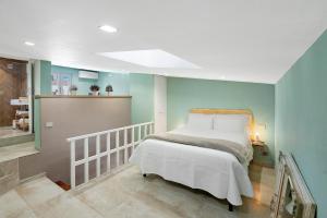 una camera da letto con un letto con lenzuola bianche e pareti blu di Civico 34 a Salerno