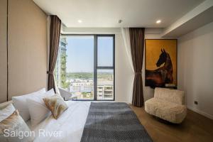 um quarto com uma cama, uma cadeira e uma janela em Lume Metro Saigon River em Cidade de Ho Chi Minh