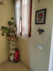 a room with a window and a vase with flowers at Ciliano 16 in Montepulciano