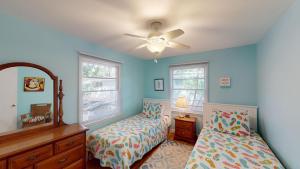 een slaapkamer met twee bedden en een plafondventilator bij Beach Oaks in Jekyll Island