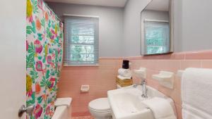 een badkamer met een wastafel, een toilet en een spiegel bij Beach Oaks in Jekyll Island +13 foto's