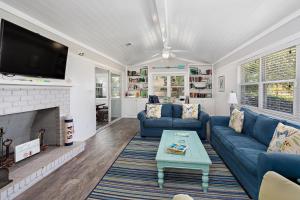 a living room with blue couches and a fireplace at Sweetpeas Cottage in Jekyll Island