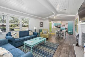 a living room with a blue couch and a table at Sweetpeas Cottage in Jekyll Island