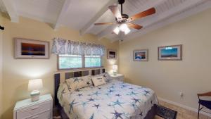 a bedroom with a bed and a ceiling fan at Barronhaus in Jekyll Island